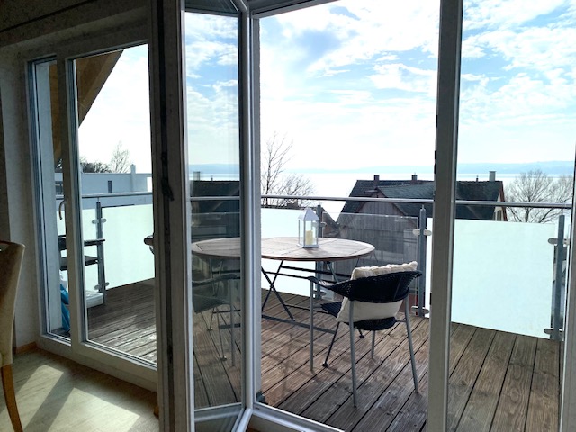 Schlafzimmer mit Doppelbett und Fenster mit Seeblick